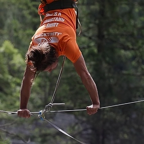 Uma pessoa praticando slackline entre duas arvores
